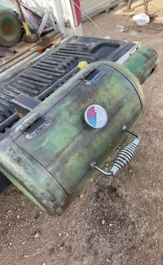 Homemade welding rig truck grill fabricated from a recycled metal cylinder with temperature gauge and spring handle